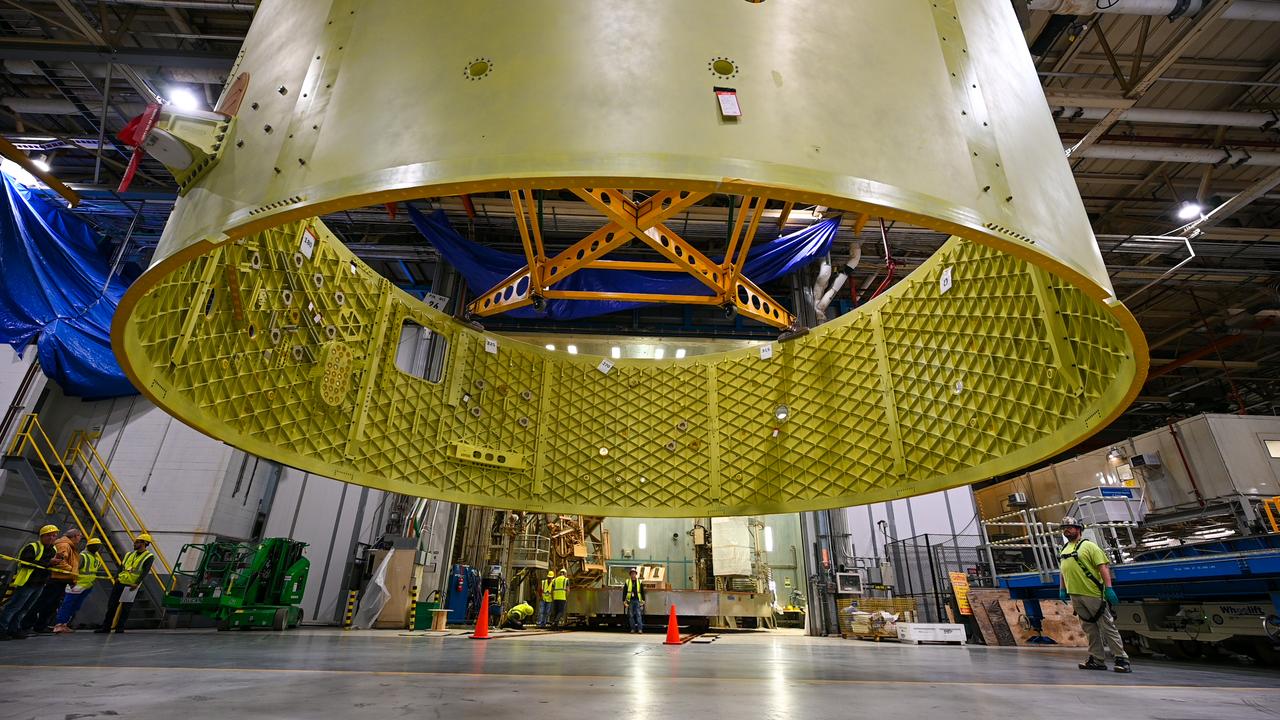 Crews at NASA’s Michoud Assembly Facility in New Orleans move the forward skirt of NASA’s Space Launch System (SLS) rocket to another part of the facility Dec. 15. Teams are preparing to apply the thermal protection system to the flight hardware, which will protect it from the extreme temperatures during launch and flight. The forward skirt is part of the core stage that will power the SLS rocket for the Artemis III mission. The forward skirt houses flight computers, cameras, and avionics.. The SLS core stage is made up of five unique elements: the forward skirt, liquid oxygen tank, intertank, liquid hydrogen tank, and the engine section. When fully stacked, the forward skirt is located at the top of the core stage and connects the stage to the upper part of the rocket. Together with its four RS-25 engines, the rocket’s massive 212-foot-tall core stage — the largest stage NASA has ever built — and its twin solid rocket boosters produce 8.8 million pounds of thrust to send NASA’s Orion spacecraft, astronauts and supplies beyond Earth’s orbit to the Moon and, ultimately, Mars. Offering more payload mass, volume capability and energy to speed missions through space, the SLS rocket, along with NASA’s Gateway in lunar orbit, the Human Landing System, and Orion spacecraft, is part of NASA’s backbone for deep space exploration and the Artemis lunar program. No other rocket is capable of carrying astronauts in Orion around the Moon in a single mission.
